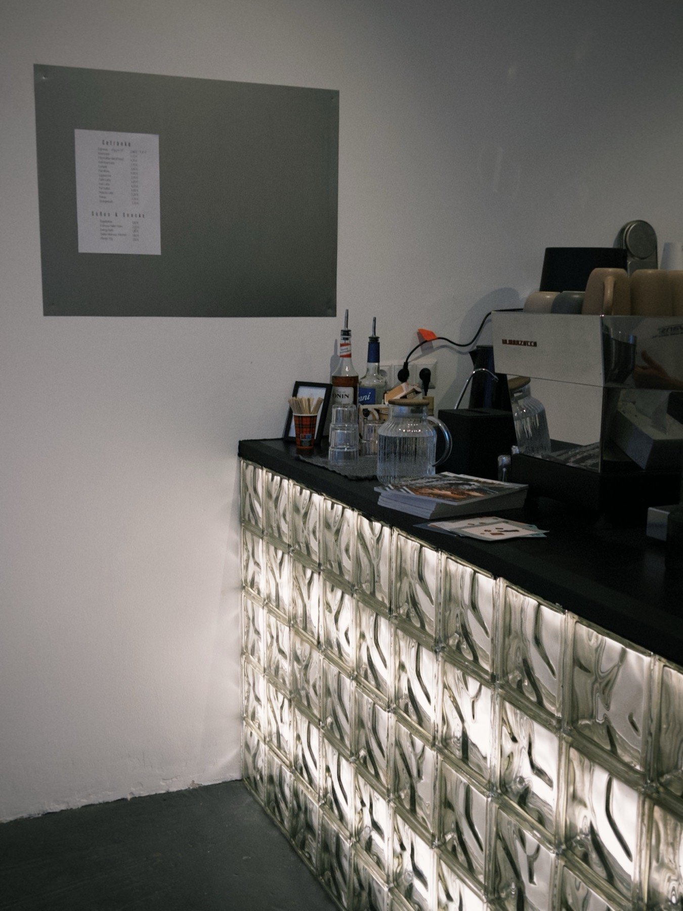 Der beleuchtete Glasbaustein-Tresen mit La Marzocco Siebträgermaschine im brüh