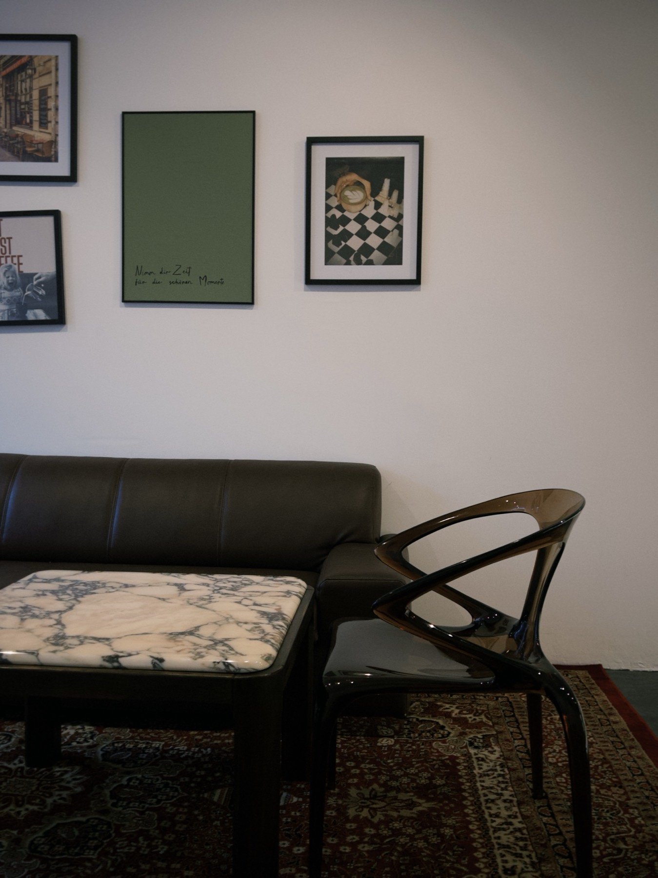 Sitzecke im brüh Kaffeebar mit Ledersofa, Marmortisch und Bildergalerie an der Wand